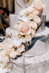 large wedding cake many tiers of floors white marble cream with flowers roses and stand on white wedding decor