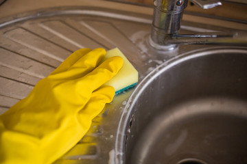Tidying up. Wash the sink in gloves with a sponge. yellow gloves and a sponge. Household products...