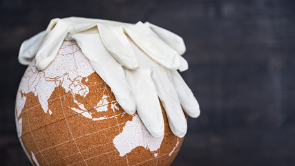 White surgical gloves lying on globe. Concept of global quarantine 