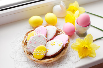 festive Easter decor is on the window eggs gingerbread and flowers. Easter cakes in a basket