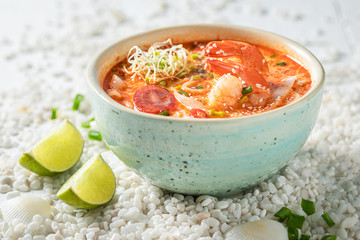 Yummy Tom Yum soup in blue bowl with lime