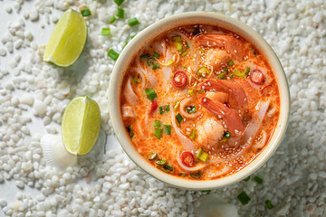 Fresh Tom Yum soup in blue bowl with lime