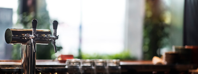 Selective focus on cold beer tap in cafe, blurred background