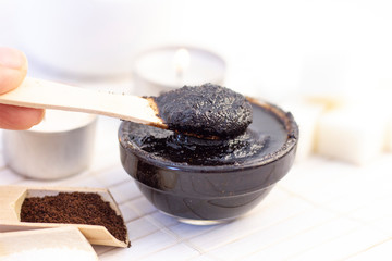 Natural scrub made from coffee and sugar. in a glass jar on a background of candles burning.