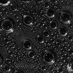 Abstract background of water drops big and small on a transparen