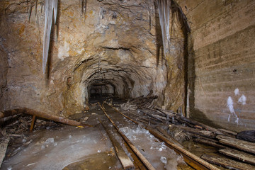 Underground abandoned bauxite ore mine tunnel with ice stalactites and stalagmites