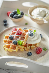 Delicious and homemade waffles with berries and whipped cream