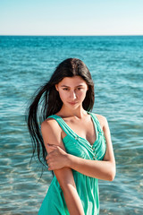 Beautiful woman on the beach. Single girl in long dress.