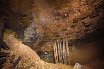 Underground abandoned bauxite mine tunnel with wooden stands