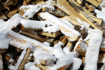 Chipped firewood for the stove, covered with snow.