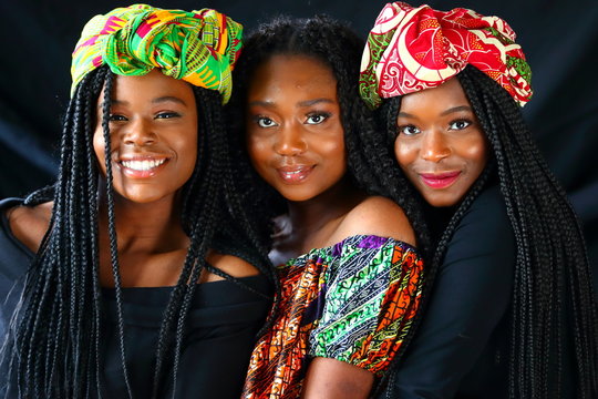 african models wearing traditional headdress posing for the camera