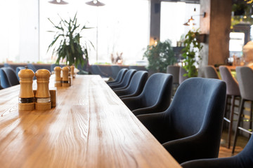 Long table in cafe for coworking, empty interior, no people