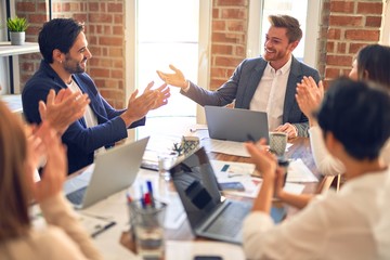 Group of business workers smiling happy and confident. Working together with smile on face applauding one of them at the office