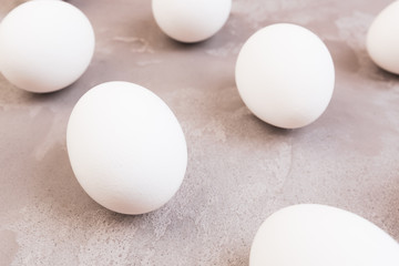 White Easter eggs on grey marble table.