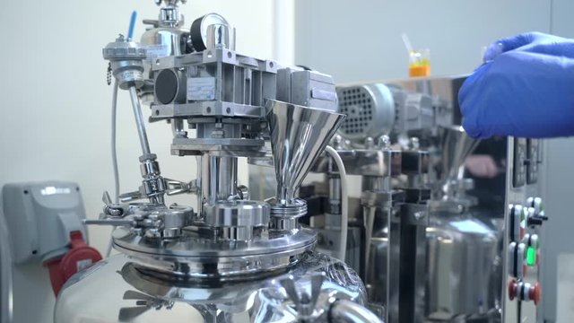 Factory worker loading pouring chemical liquid into medicine production machine Spbas. Process of medicaments production at pharmacological factory, plant, laboratory