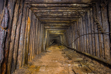 Underground abandoned bauxite ore mine tunnel with wooden timbering