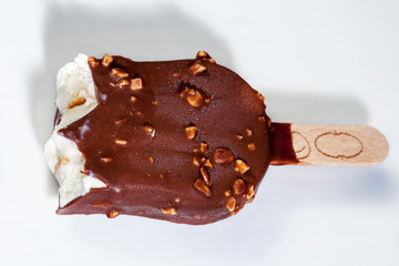 Ice cream sundae coated with chocolate on a slate board. Popsicle on a stick