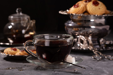 Tea and cookies in vintage utensils on a gray background