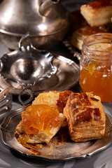 Puff pastry cookies in vintage utensils on a gray background