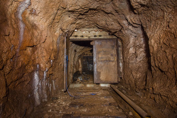 Underground abandoned bauxite ore mine tunnel with doors