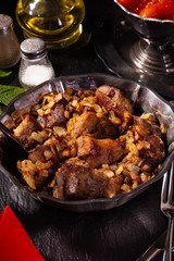 Braising meat with Italian herbs in a metal plate