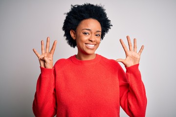 Young beautiful African American afro woman with curly hair wearing red casual sweater showing and...