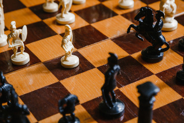 Chess white and black pieces fight on the battlefield for their king