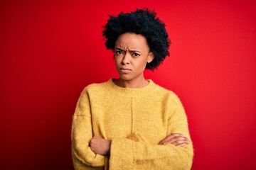 Fototapeta na wymiar Young beautiful African American afro woman with curly hair wearing casual yellow sweater skeptic and nervous, disapproving expression on face with crossed arms. Negative person.