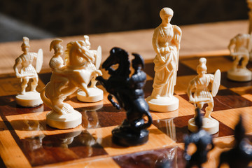 Chess white and black pieces fight on the battlefield for their king