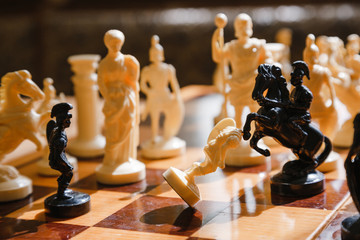 Chess white and black pieces fight on the battlefield for their king