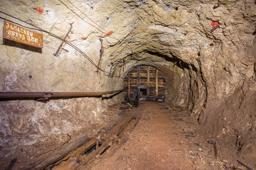 Underground abandoned bauxite ore mine tunnel with broken wall