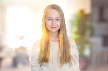 Fototapeta premium Little girl smiling portrait indoor against of sunset light