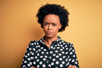 Fototapeta na wymiar Young beautiful African American afro woman with curly hair wearing casual shirt standing skeptic and nervous, disapproving expression on face with crossed arms. Negative person.