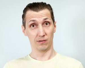 Obraz premium Portret mężczyzny zaskoczony, szare tło, seria emocji.