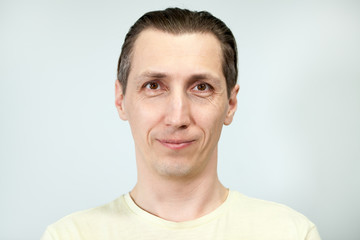 Obraz premium Portret uśmiechniętego i spokojnego mężczyzny, szare tło, seria emocji