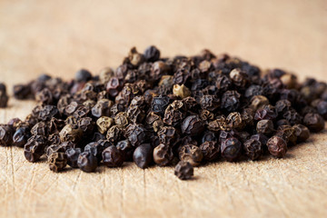 Closeup heap a whole pepper seeds on wooden background.