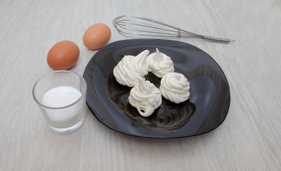 meringues on black plate and white background