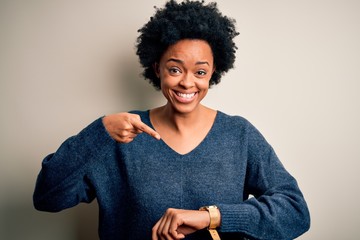 Young beautiful African American afro woman with curly hair wearing casual sweater In hurry...