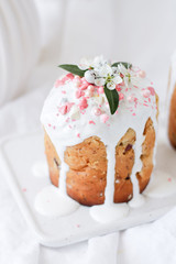 close-up Easter composition with Orthodox sweet bread, Easter cake decorated with eggs, sweets and flowers and pink hearts on a light background. Easter holidays breakfast concept.