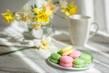 Obraz na płótnie Canvas a Cup of tea with macaroons morning Breakfast with a bouquet of flowers in a vase