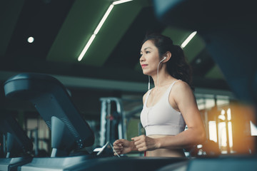 Fototapeta na wymiar Young fitness woman on the treadmill in the gym.