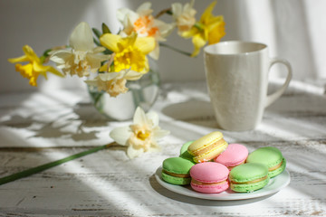 a Cup of tea with macaroons morning Breakfast with a bouquet of flowers in a vase