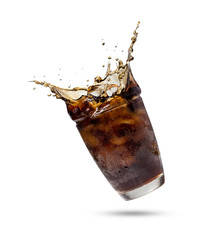 Studio shooting Cola splashing out of a glass.Cola in glass with splash of ice isolated on white...