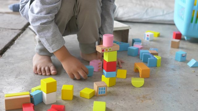Asian child boy hand playing wooden colorful blocks outdoor at home, happy family activity fun time, learning ef concept. 4K