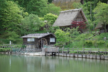 Fototapeta na wymiar Japanese historical garden with watermill and riverbank