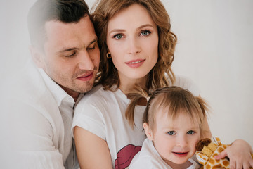 Cute kid daughter and dad tickling mom having fun good time playing together at home, happy parents...