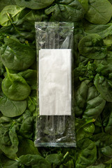 take away transparent plastic pouch with napkin and cutlery on spinaches