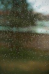Naklejka na ściany i meble An image in a window with raindrops