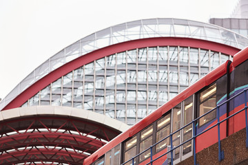 A city subway train enters an arched atrium in a modern city environment