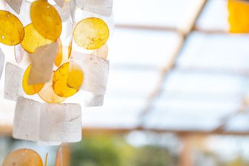 Yellow and orange wind chime hanging in front of window